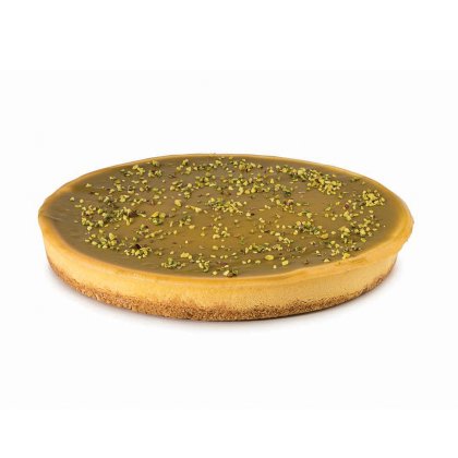 Runde Tarte mit glattem Karamellglanz, mürbem Boden und gehackten Pistazien bestreut.