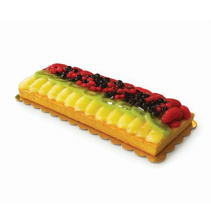 Rechteckige Obsttorte mit Mango- und Kiwischeiben, glasierten Beeren und Erdbeeren auf goldenem Kartonboden.