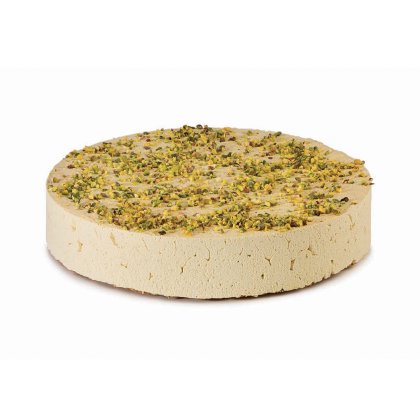 Runde Scheibe helle Halva mit gehackten Pistazien, dichte, krümelige Textur auf weißem Hintergrund.