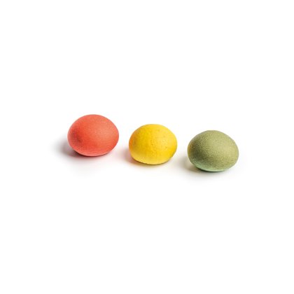 Drei runde, strukturierte Bonbons in Rot, Gelb und Grün, nebeneinander auf weißem Hintergrund.