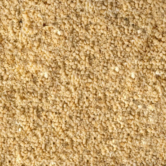 Nahaufnahme von feinem, körnigem, hellgelbem Pulver mit grober, krümeliger Textur, das den gesamten Bildbereich einni...
