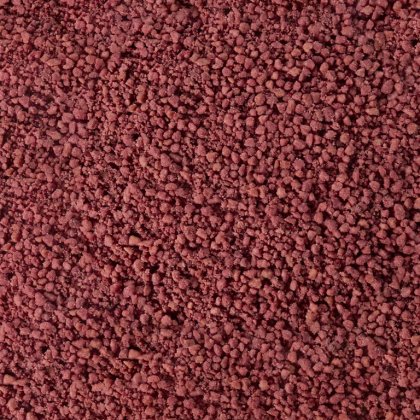 Nahaufnahme grober, rotbrauner Granulate oder Pulver, ähnlich verklumpten Mineral- oder Gewürzkörnern