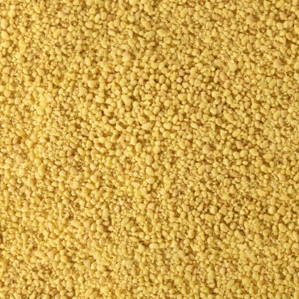 Nahaufnahme feiner gelber körniger Textur, ähnlich grobem Maisgrieß oder trockenem Couscous.