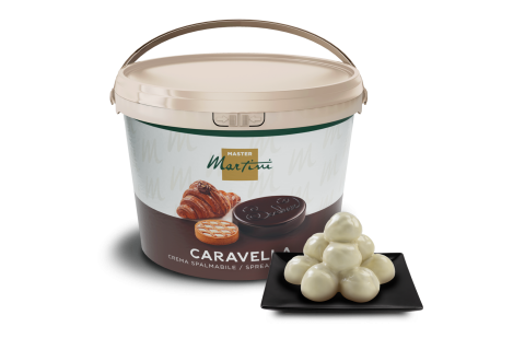 Becher Master Martini Caravella Aufstrichcreme mit weißen Schokoladentrüffeln auf schwarzem quadratischem Teller.