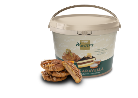 Großer Eimer Master Martini Caravella Streichcreme neben gefüllten Gebäckstücken mit weißer Schokoladenglasur.