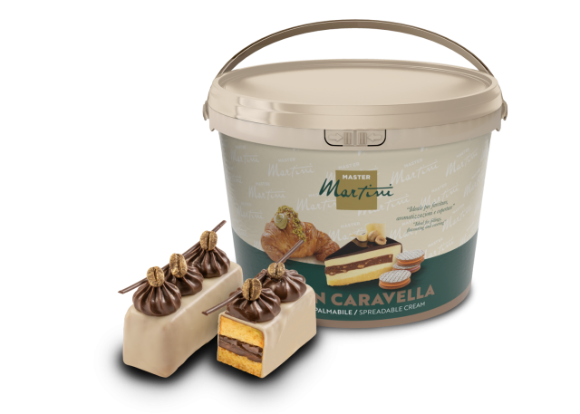Großer Eimer Master Martini Aufstrichcreme neben schokoladenglasiertem Gebäck mit Creme und Biskuit.