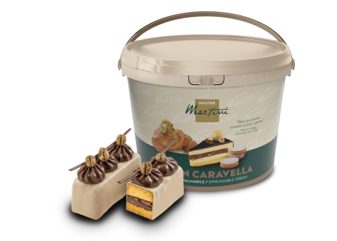 Großer Eimer Master Martini Aufstrichcreme neben schokoladenglasiertem Gebäck mit Creme und Biskuit.