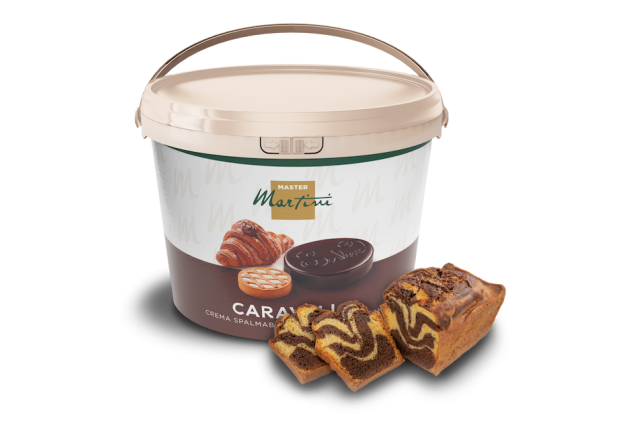 Großer Eimer Master Martini Caravel Streichcreme neben geschnittenem marmoriertem Kakao-Vanille-Kuchen