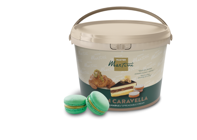Beige Dose Master Martini Streichcreme mit Gebäckbildern, neben zwei grünen Pistazien-Macarons.